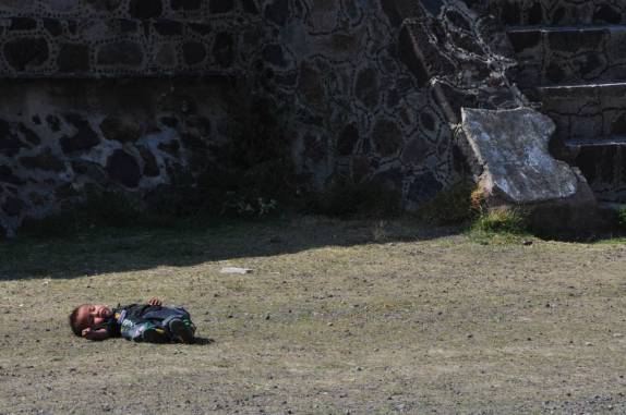 Criança descansa em gramado nas ruínas de Teotihuacán, ao norte da Cidade do México
